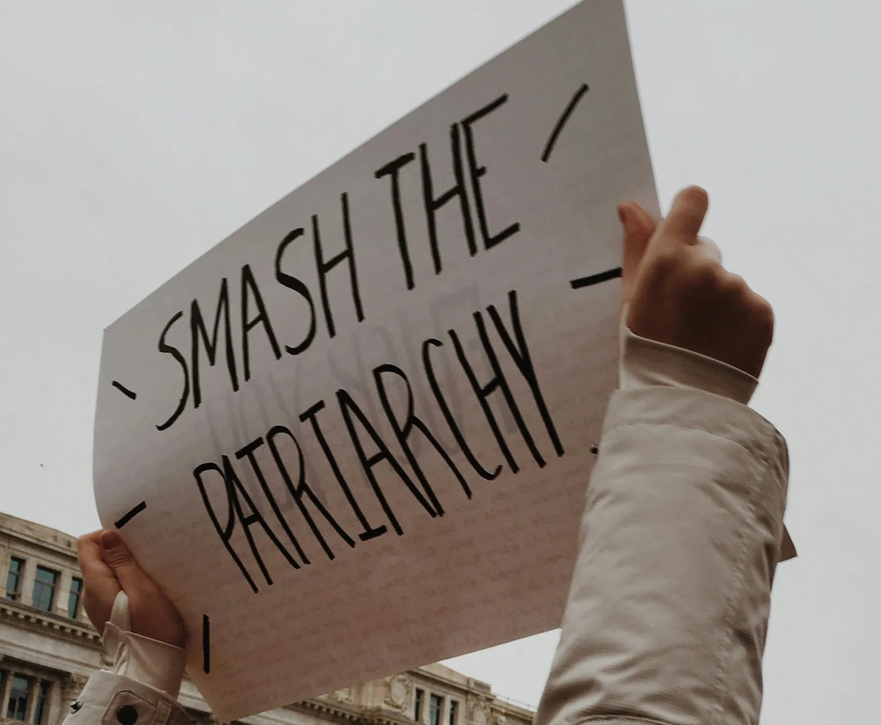 Woman holding white paper with smash the patriarchy
